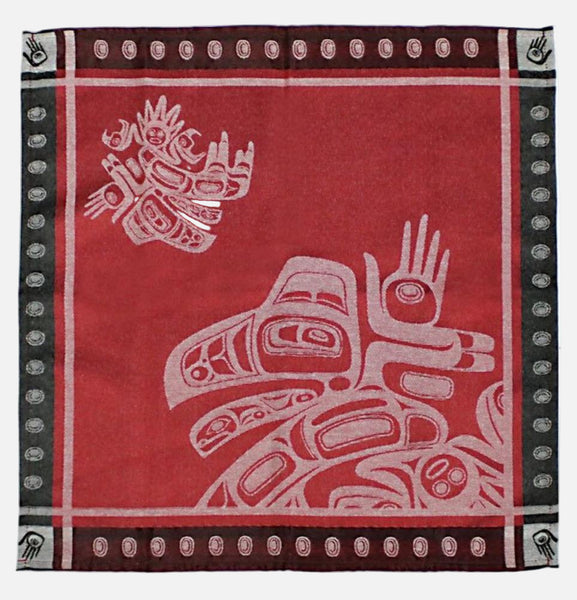 A red jacquard woven napkin with a black dotted border light-red Raven designs.