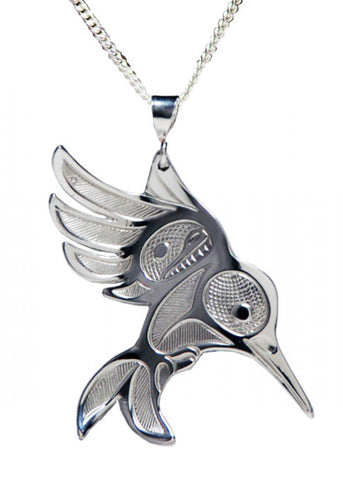 A silver pendant in the shape of a formline Hummingbird, strung on a thin silver chain.