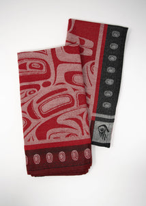 A pair of red jacquard woven napkins with a black dotted border light-red Raven designs. The napkins are folded vertically and slightly overlapping.