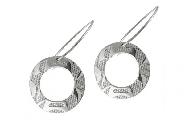 Dangle earrings of circular cut-out silver discs with round embossed designs.