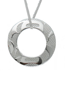 A circular cut-out silver pendant, with round embossed designs, strung on a thin silver chain.